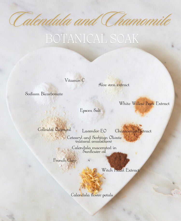 Calendula and Chamomile Botanical Soak ingredients arranged on a heart-shaped marble slab, each labeled by name