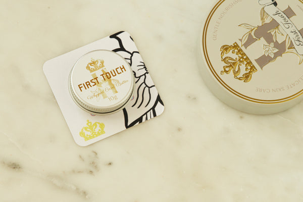 First Touch pocket-size tin on a printed card beside the full-size tin