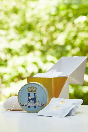 Butter in Blue tin and soak sachets beside an open gold ritual box outdoors