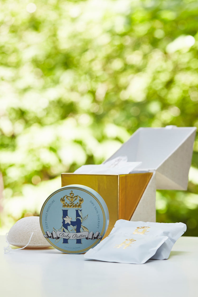 Butter in Blue tin and soak sachets beside an open gold ritual box outdoors