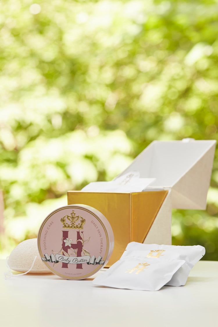 Butter in Pink tin and soak sachets beside an open gold ritual box outdoors