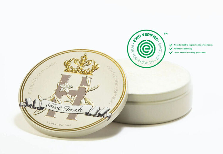 First Touch tin with its lid beside it and an EWG Verified badge