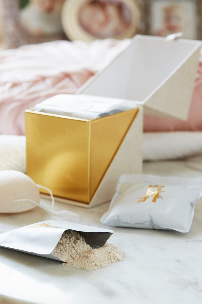 Open gold-lined ritual box with soak powder spilling from a pouch and a soak sachet