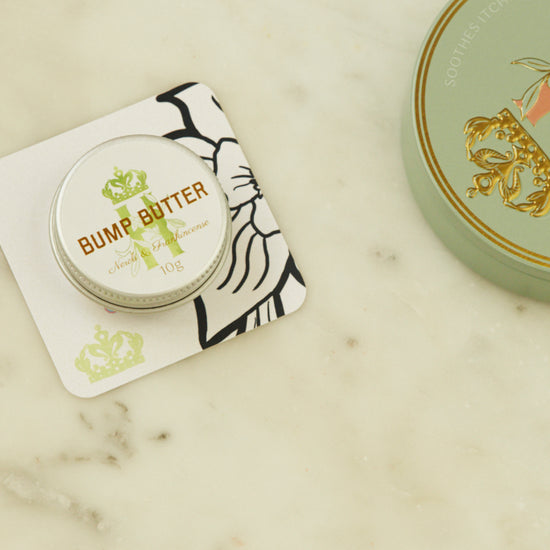 Bump Butter pocket-size tin on a printed card beside the full-size tin