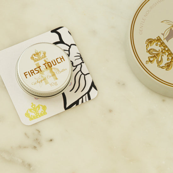 First Touch pocket-size tin on a printed card beside the full-size tin