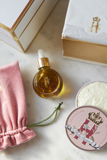 Serum bottle, a pink pouch, a Butter in Pink tin and an open box with soak sachets
