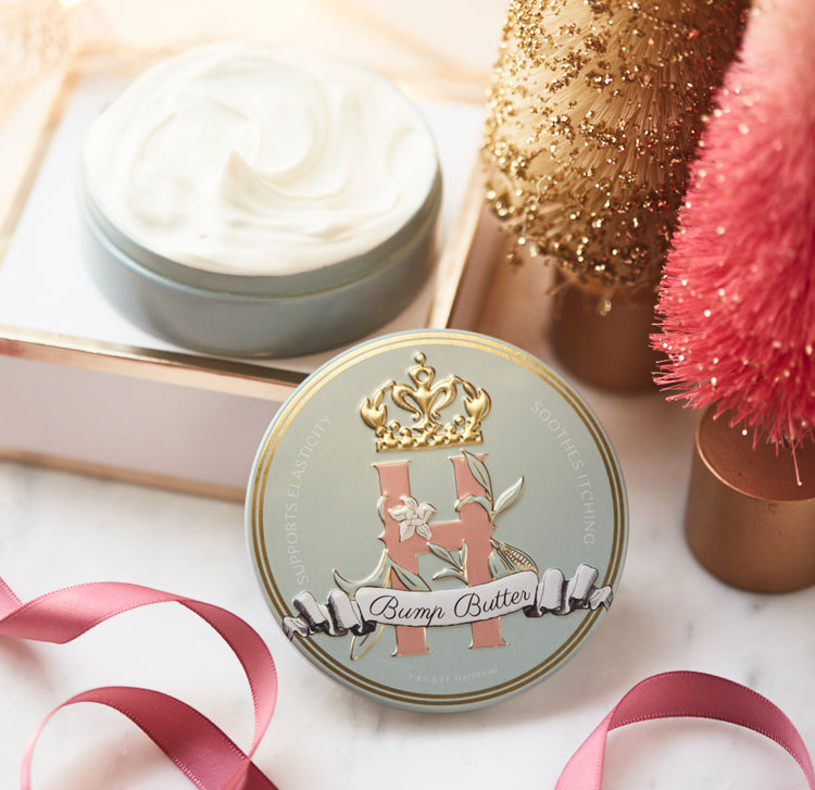 Bump Butter tin with an open tin of whipped butter, a pink decorative tree and gold ornaments