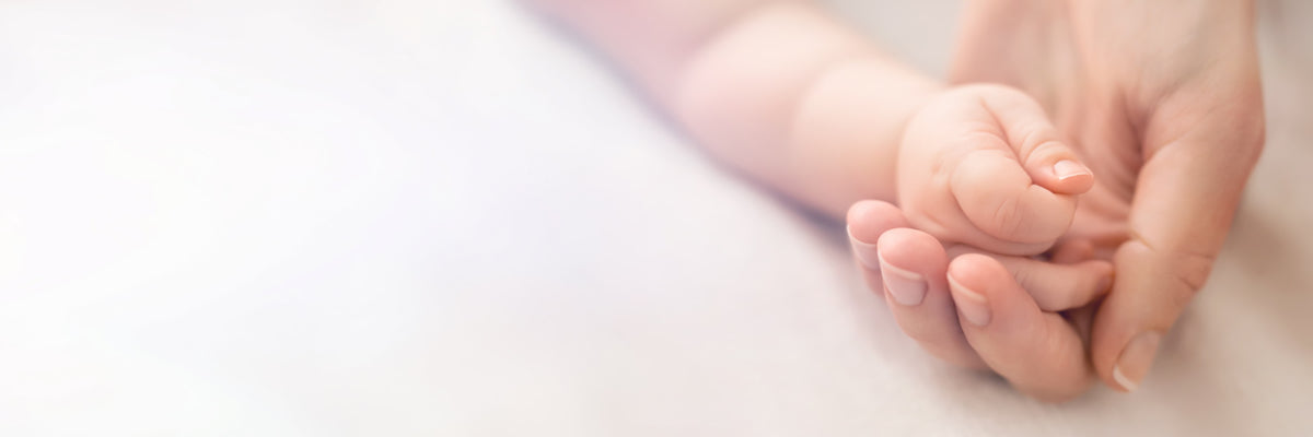 A mother and baby's hands touching
