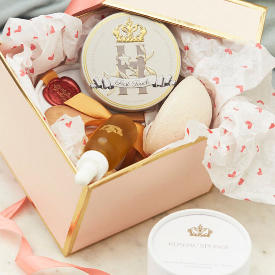 Open pink Royal Heir gift box with a butter tin, a serum bottle and a konjac sponge